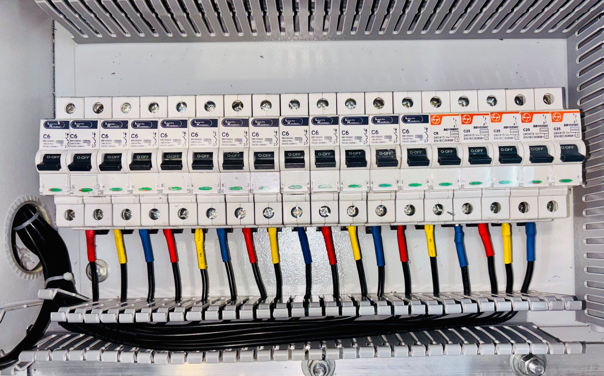 A neatly wired distribution board with colour-coded cables and breakers