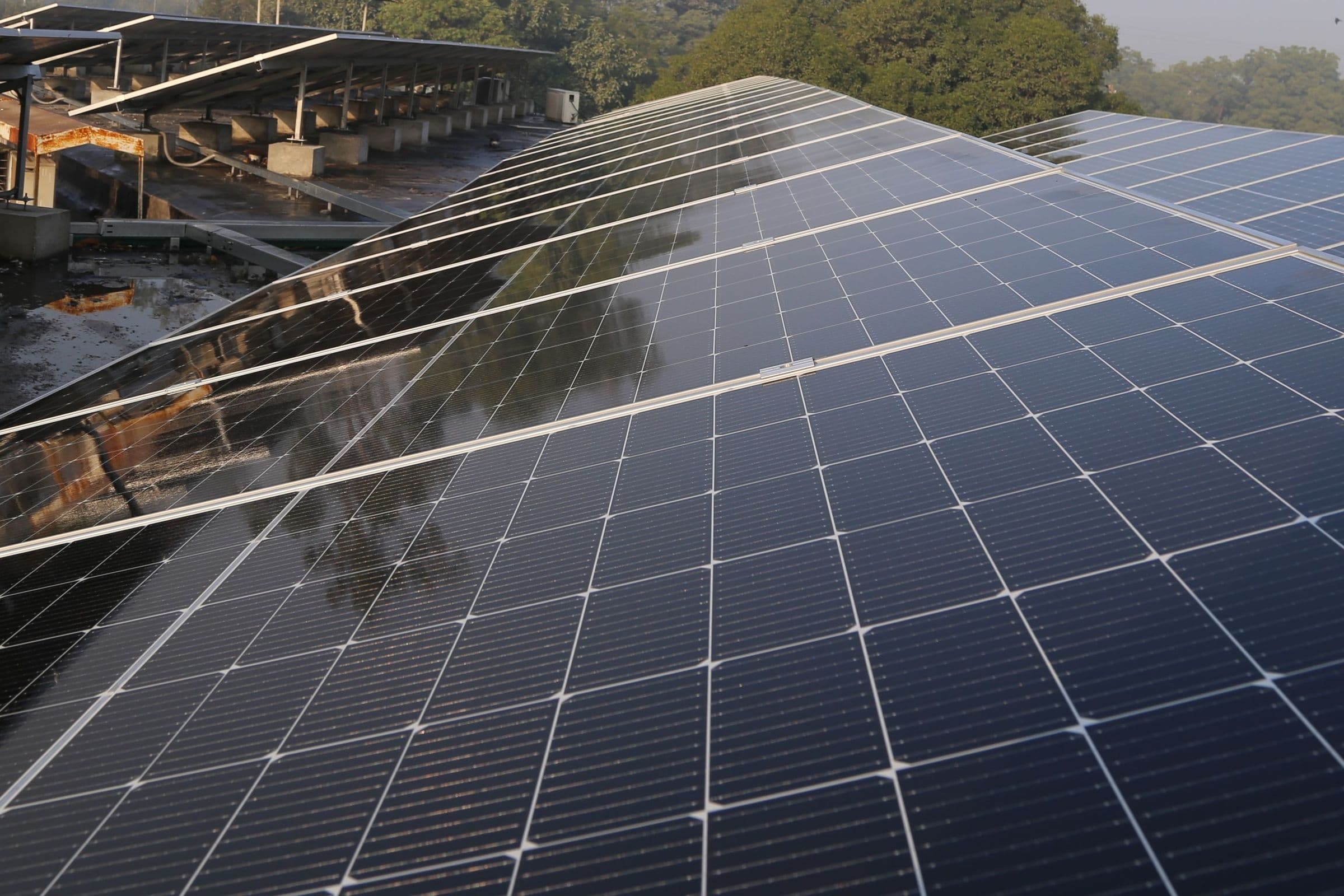An elevated solar array on a flat concrete terrace, with more rooftop arrays beyond